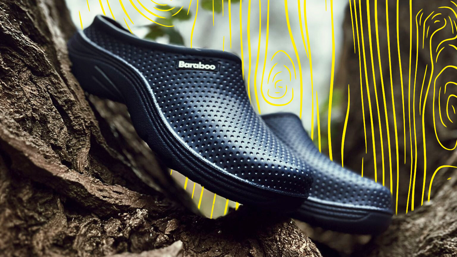 Black slip-on shoes with 'Baraboo' branding on a textured surface with abstract yellow and white pattern in the background.